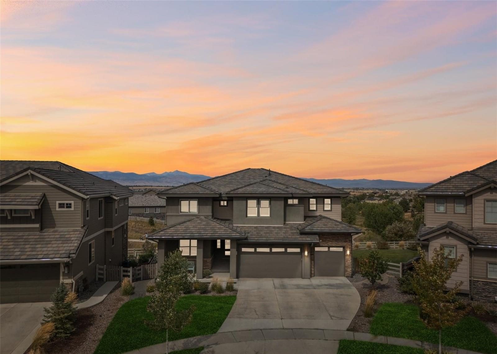 Two-story home in Anthem Highlands at dusk, with the Front Range beyond.