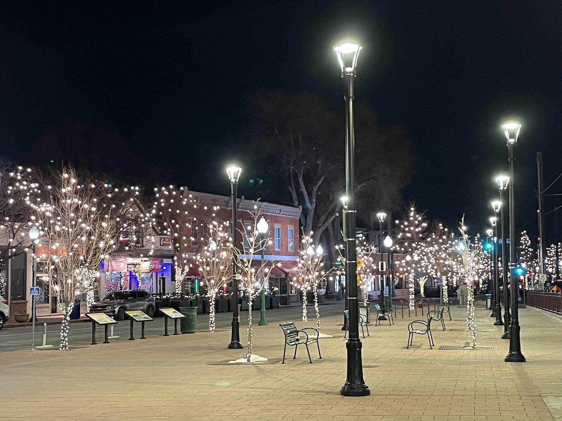 Olde Town Square in Arvada at night, with lights strung through the trees.