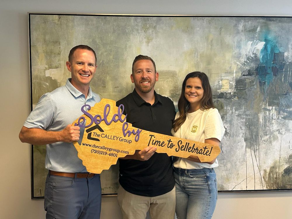 Steve Calley with a couple holding the Time to Sellebrate key sign after closing.