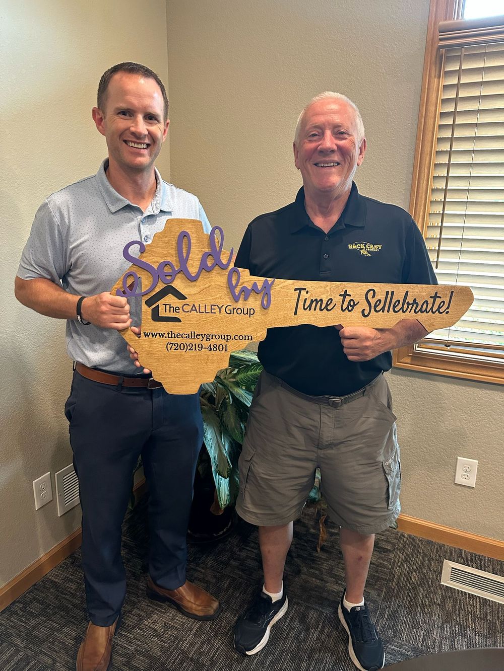 Steve Calley with a client holding the Time to Sellebrate key sign.
