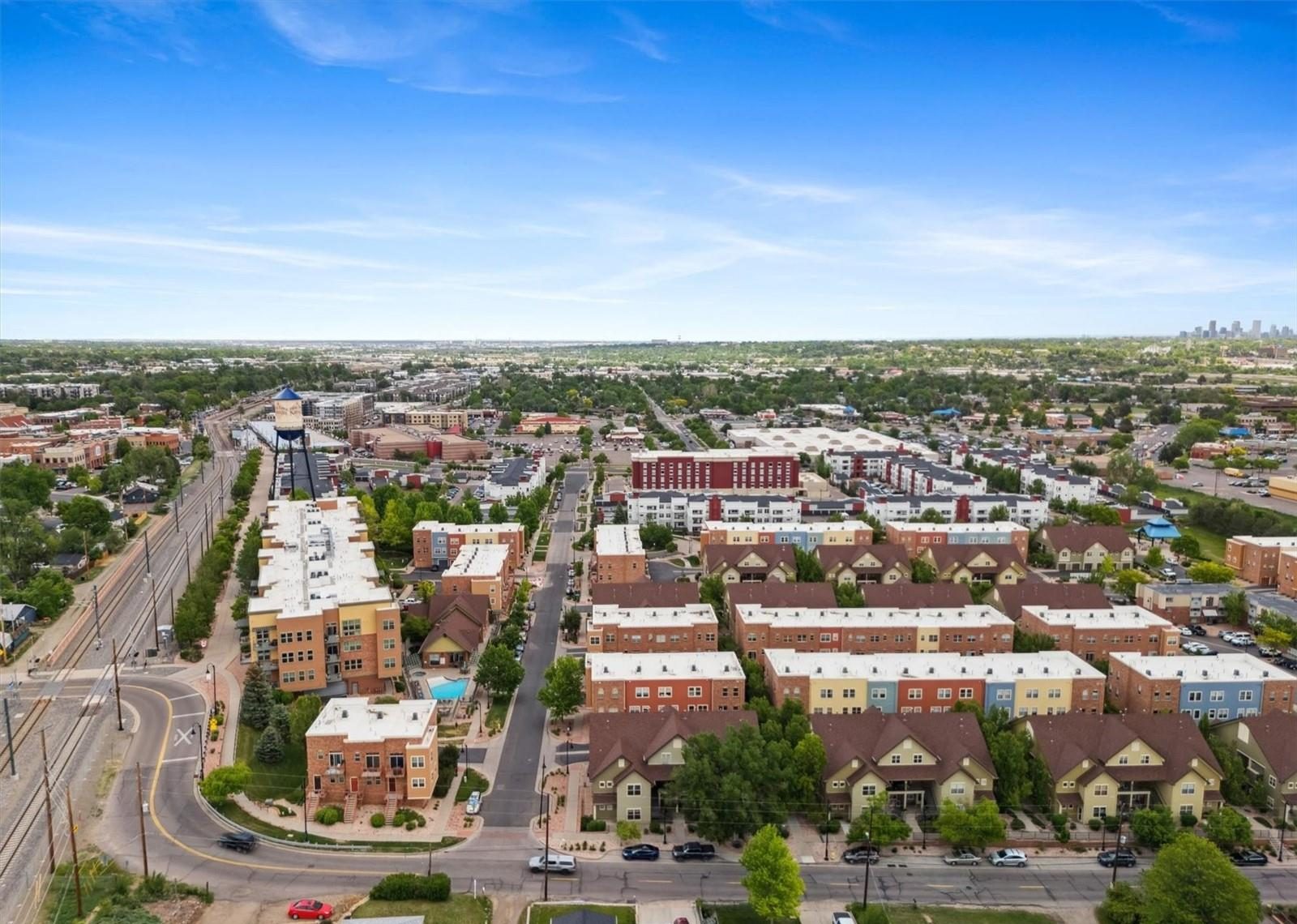 Aerial view over central Arvada near Olde Town, with the Denver skyline on the horizon.