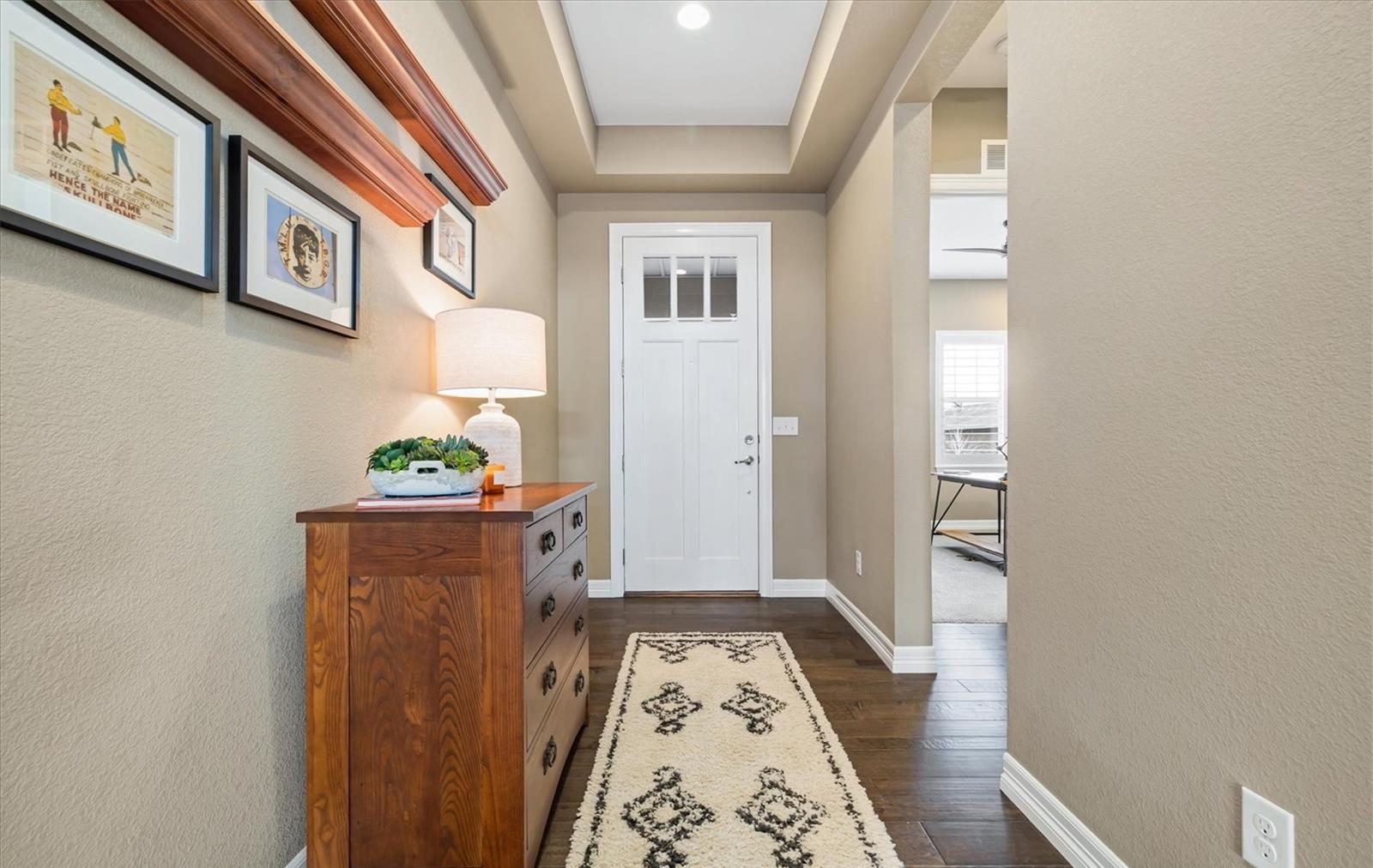 Entry hall with a runner rug and framed art in an Anthem Highlands home.