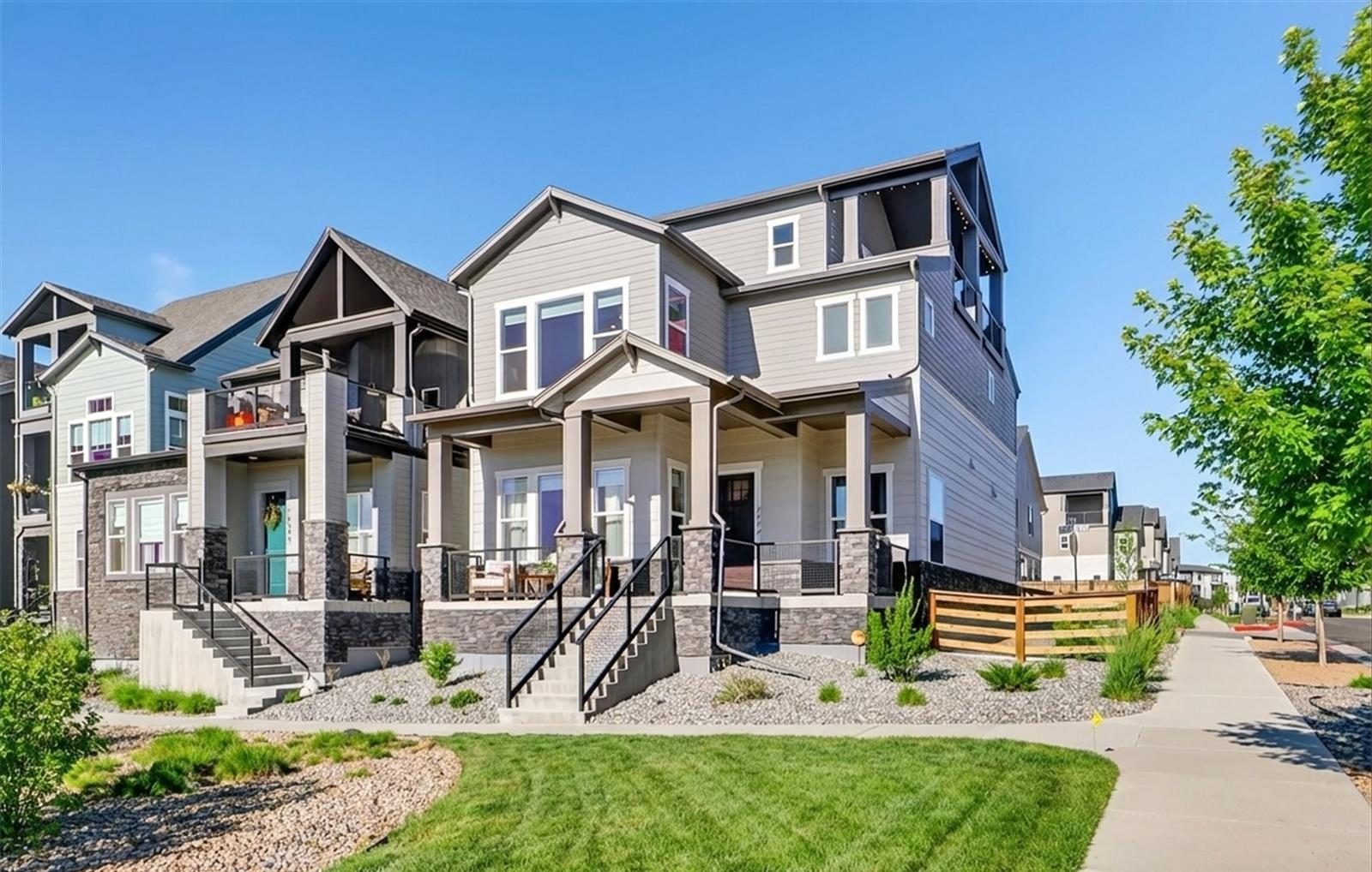 Row of newer three-story homes with covered front porches in Broomfield.