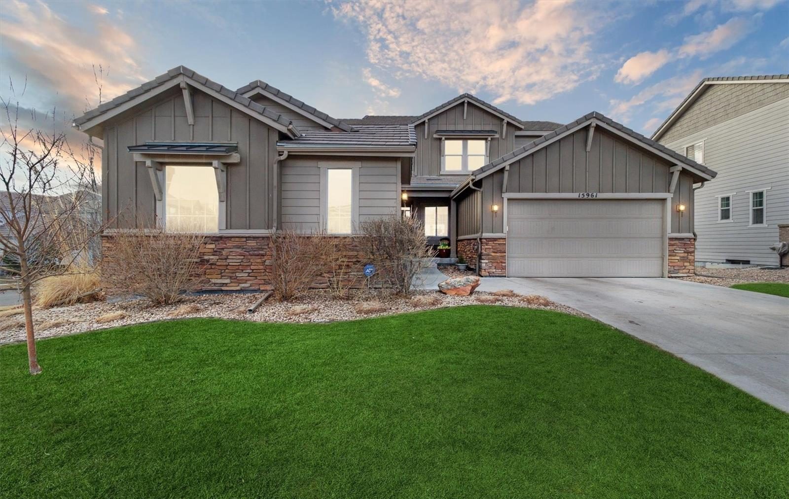 Gray two-story home on a green lawn in Anthem Highlands.