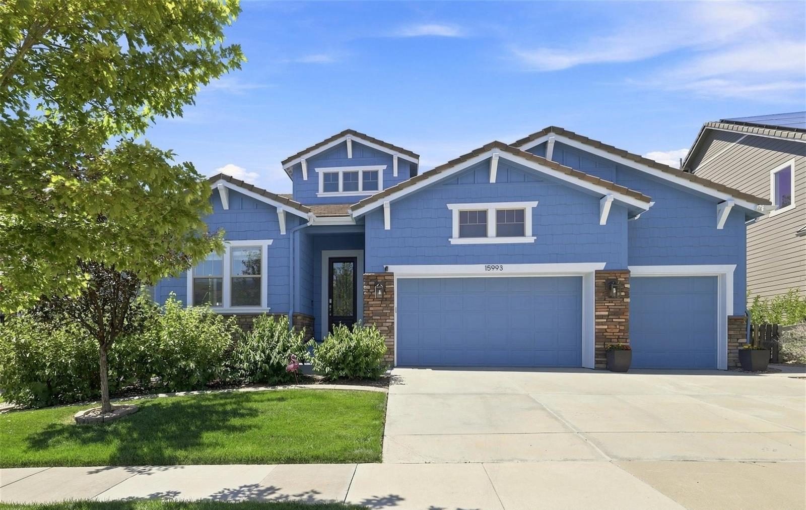 Blue ranch-style home with a wide driveway in Anthem Highlands.