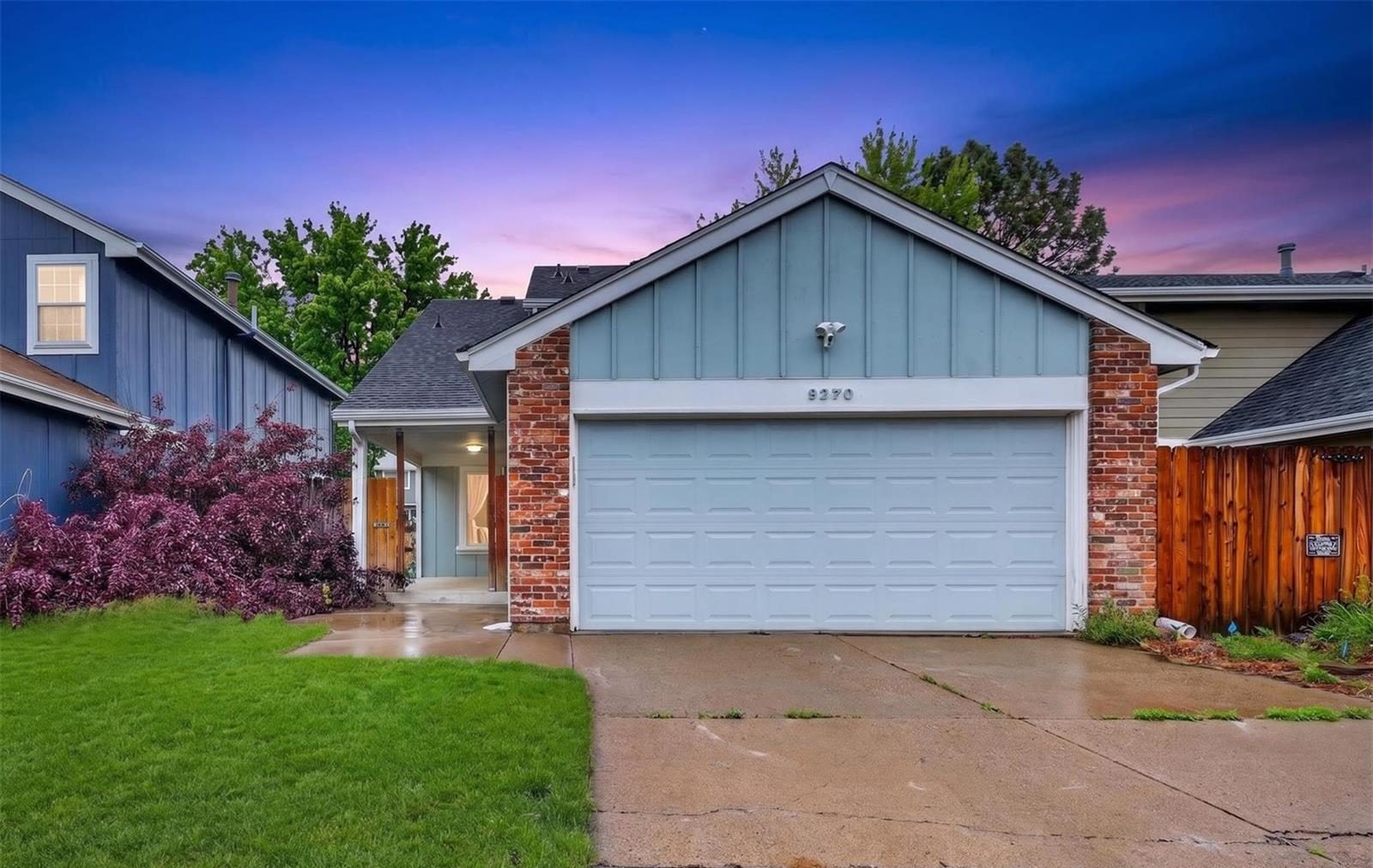 Arvada home with a blue garage door at dusk.