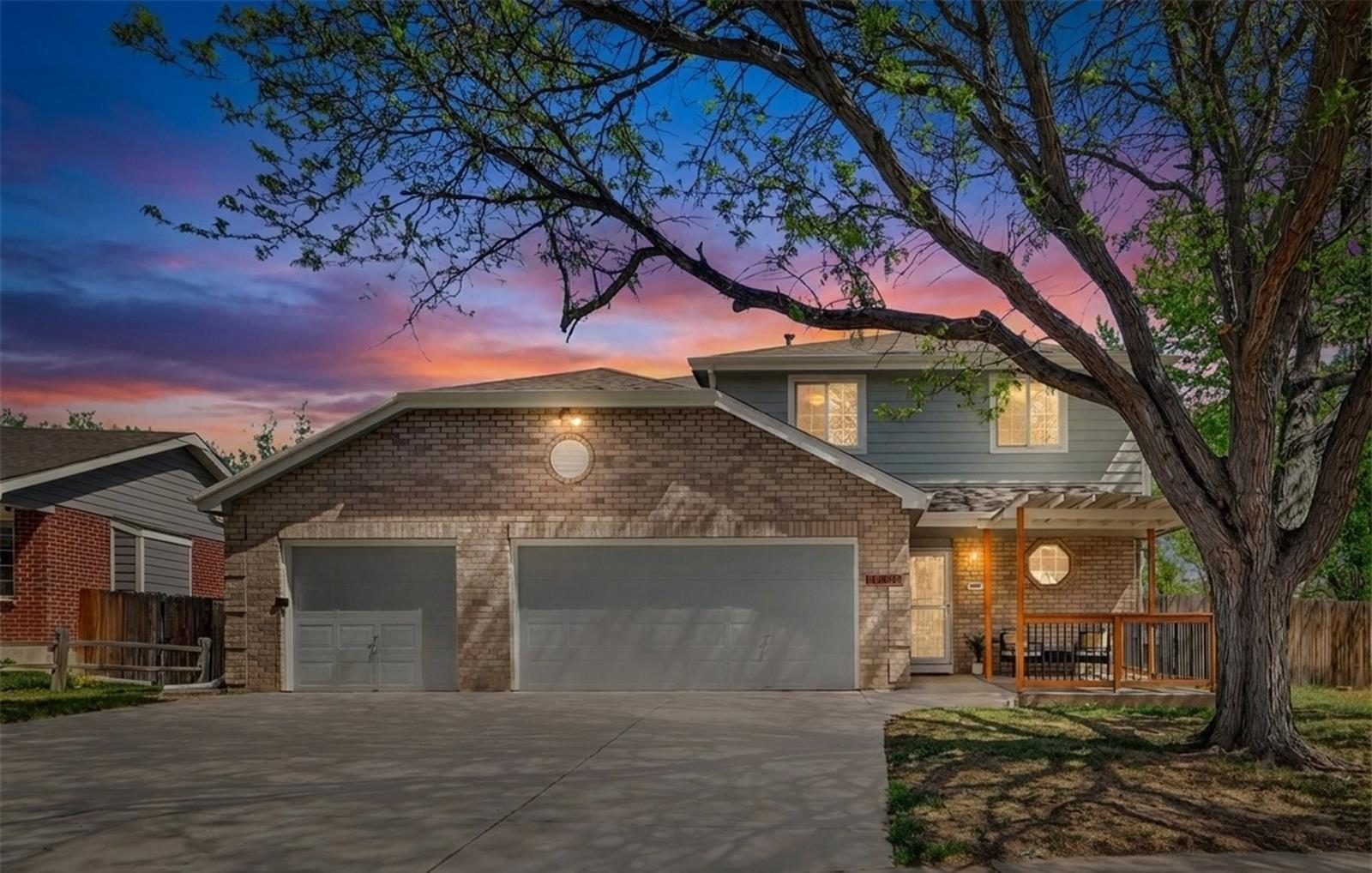 Brick two-story home in Broomfield at dusk.