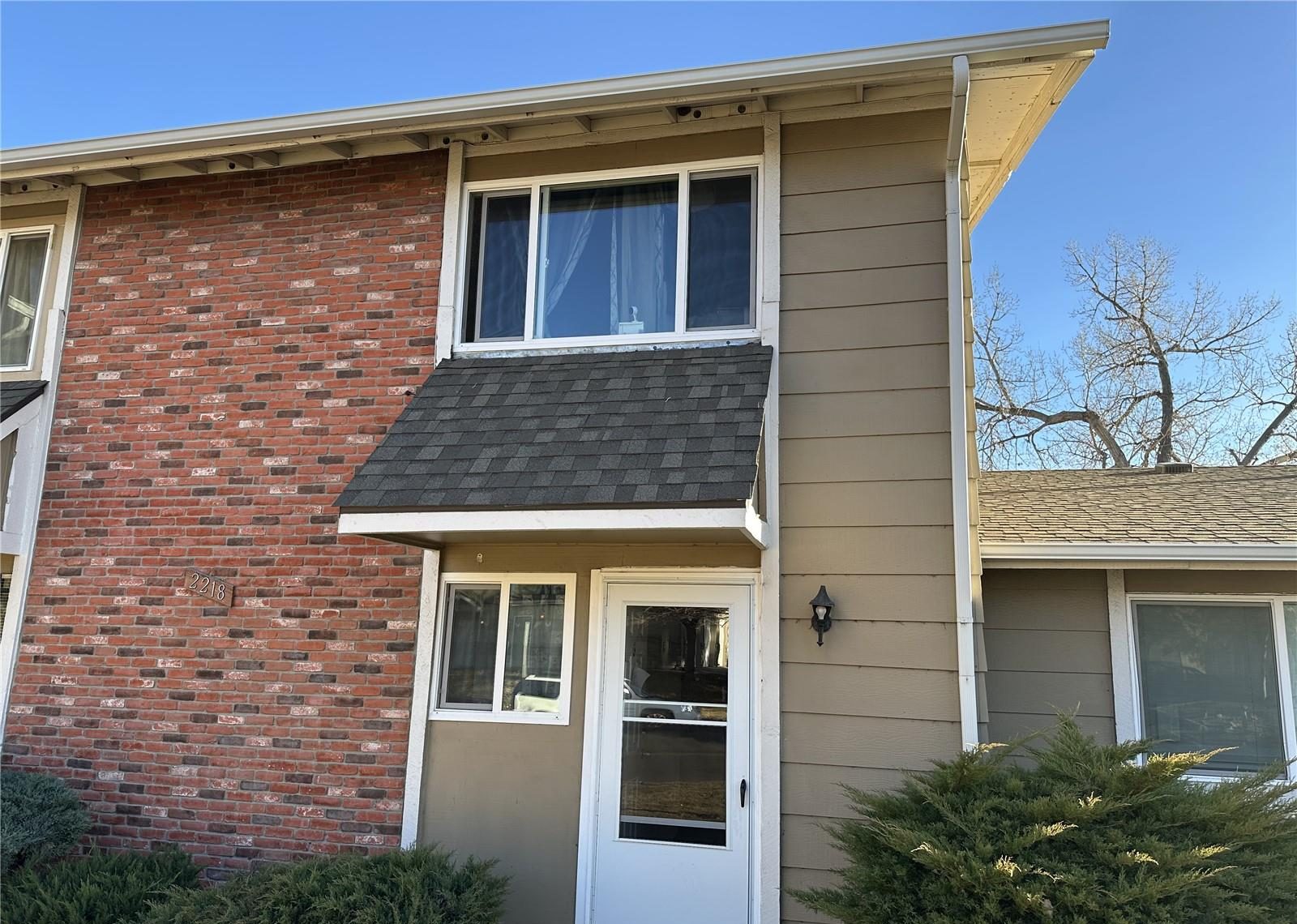 Two-story condo building with brick and siding in north Denver.
