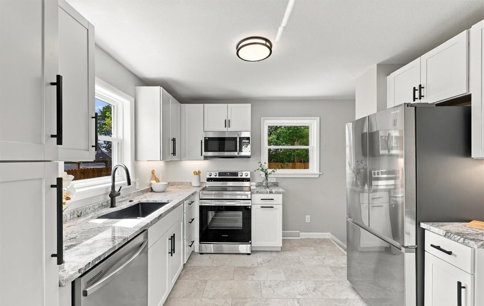 Renovated white kitchen with stainless appliances.