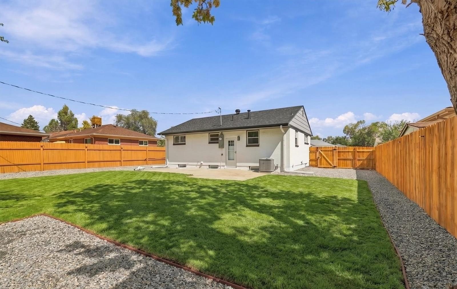 Fenced backyard with new sod behind a Denver ranch home.