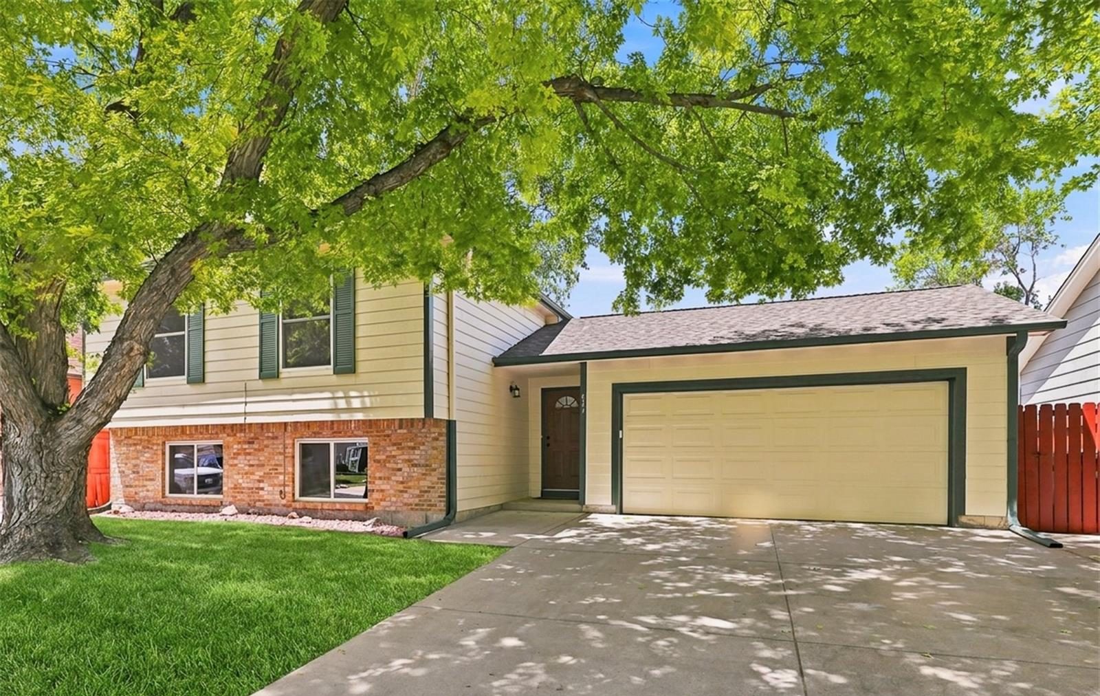 Split-level home under a large shade tree in central Broomfield.
