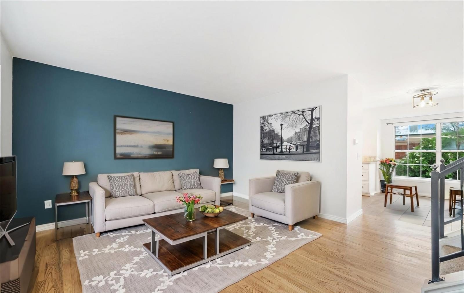 Bright living room with a gray sofa and a patterned rug.