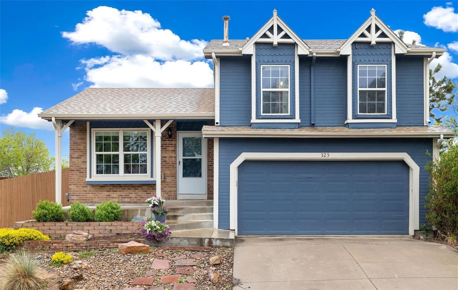 Blue two-story home with a two-car garage in central Broomfield.