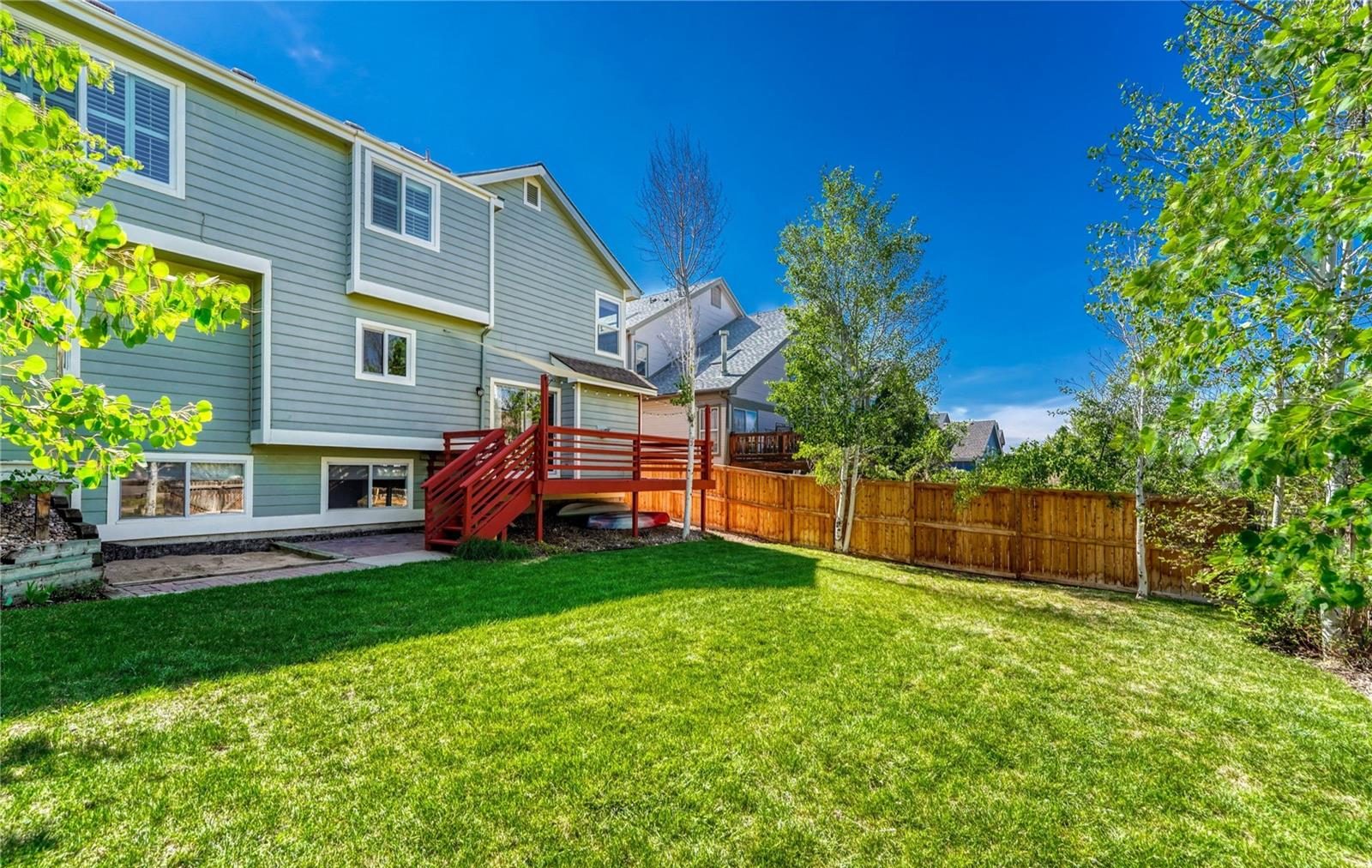 Backyard with a deck and aspen trees.