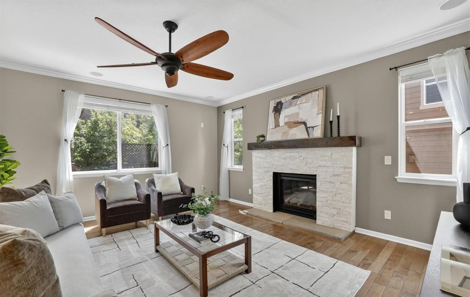 Living room with a fireplace and a ceiling fan.