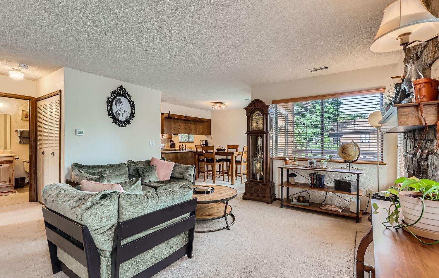 Living room with a stone fireplace and a round coffee table.