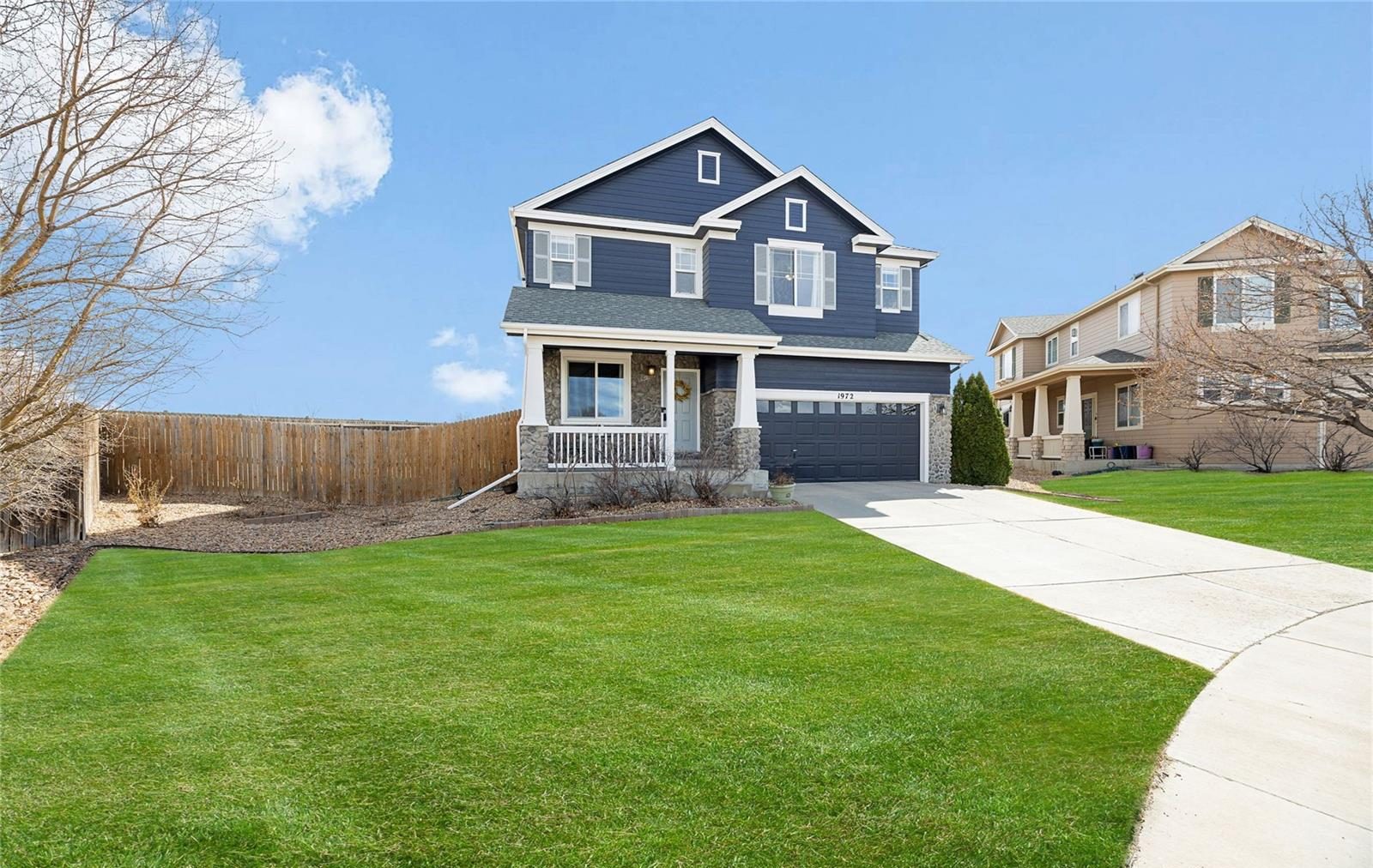 Newer navy two-story home with a wide lawn in north Thornton.