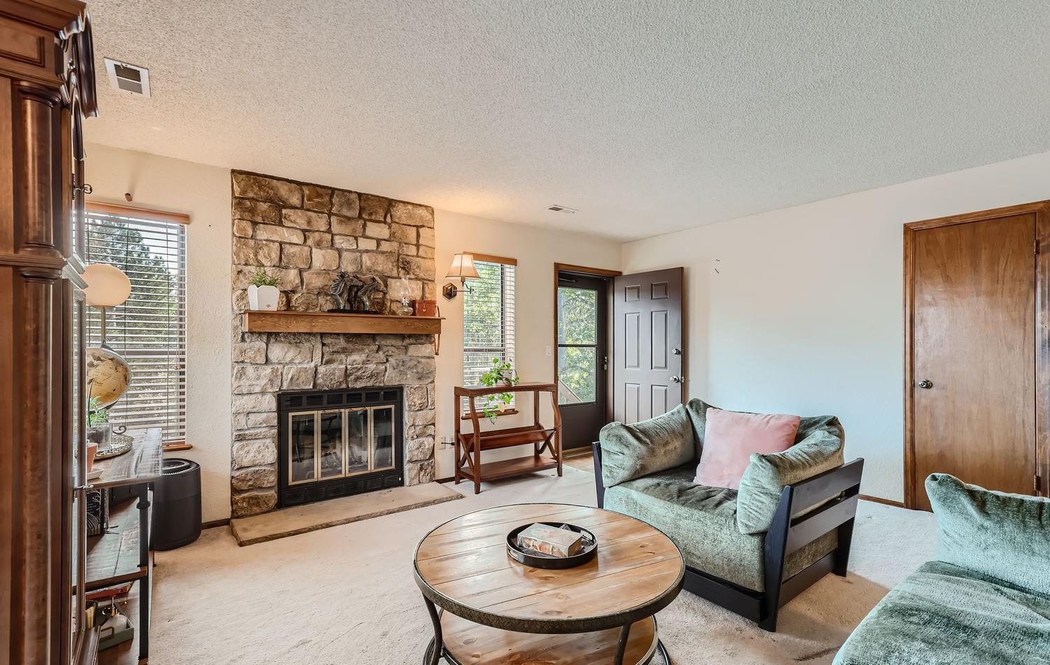Living room with a stone fireplace in a Westminster townhome.