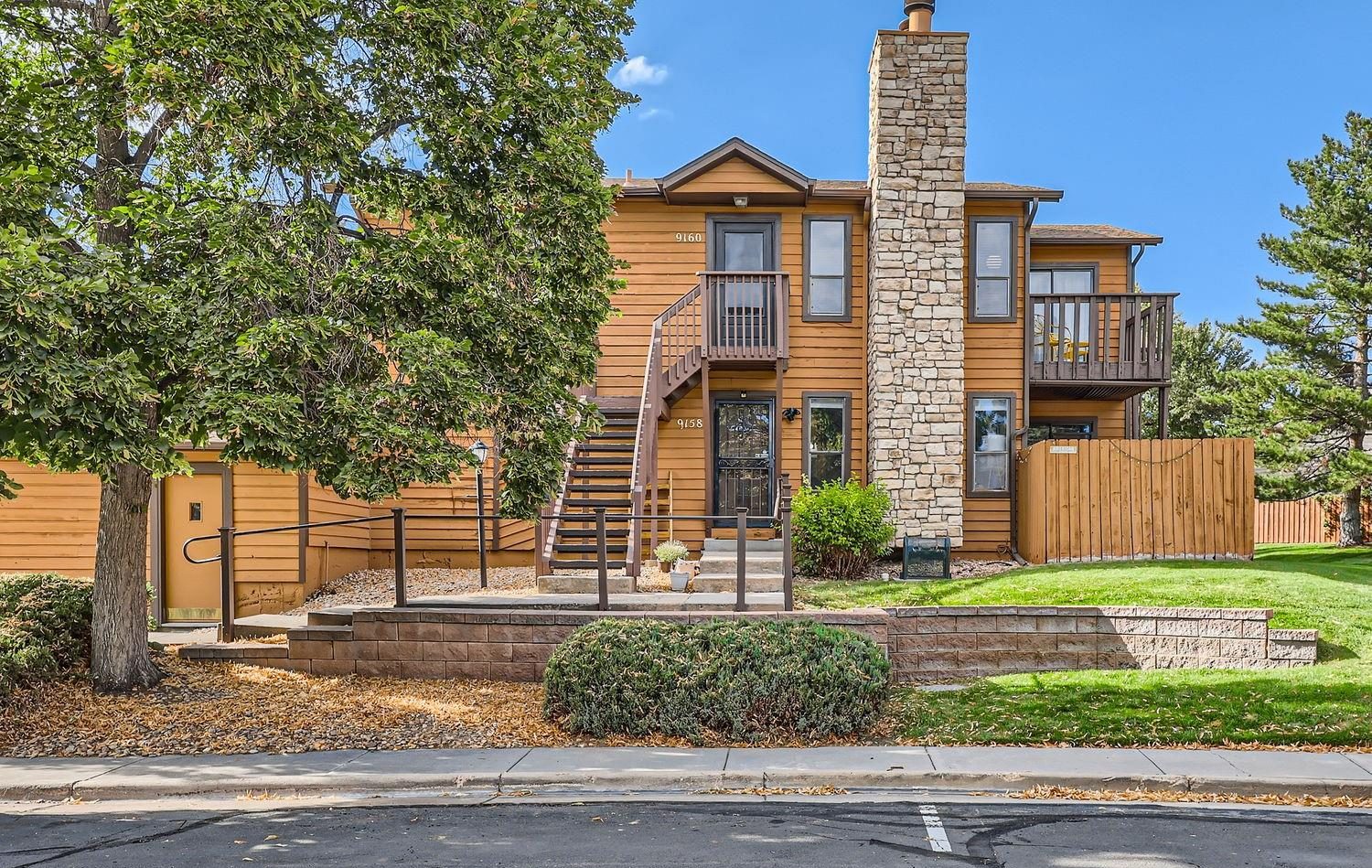 Wood-sided townhomes with a stone chimney in Westminster.