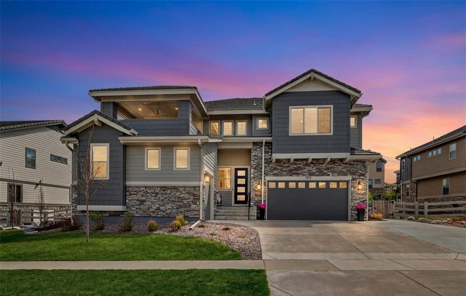 A two-story Broomfield home with a stone front and lit windows at dusk, sold by Steve Calley.