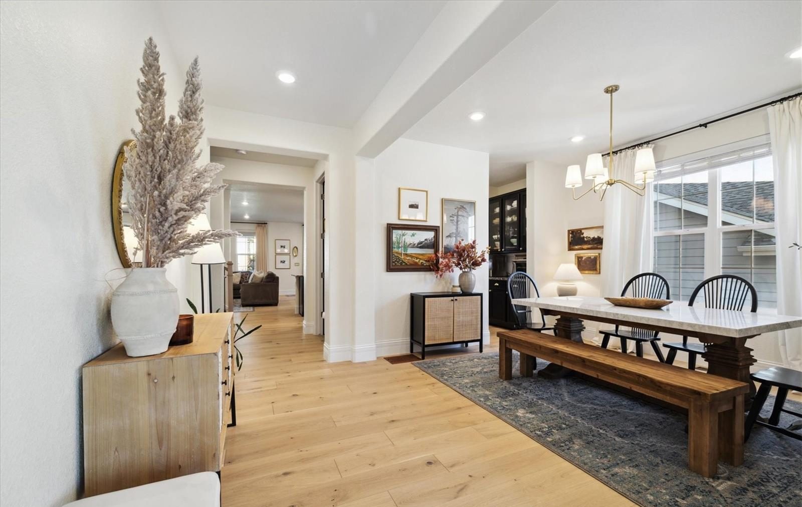 Dining room with a long farmhouse table and bright windows.