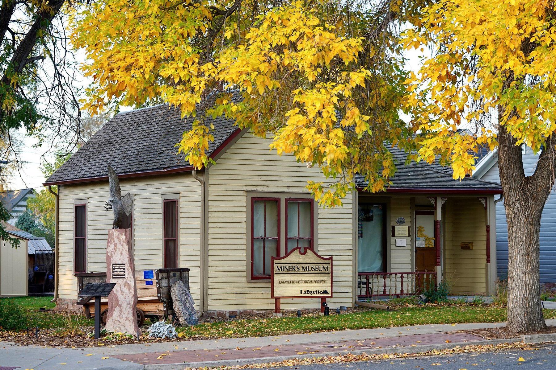 The Lafayette Miners Museum cottage under yellow fall trees.
