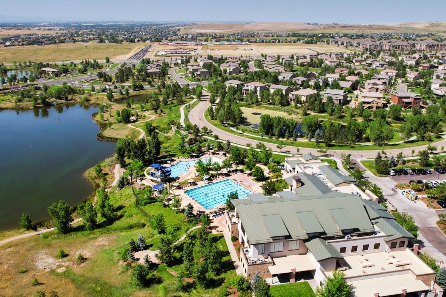 Aerial view of the Anthem Highlands community center and pools beside the lake.