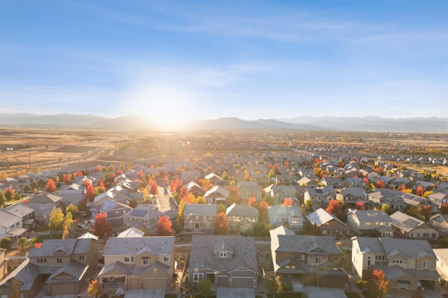 The sun setting over the rooftops of Anthem Highlands and the Front Range.