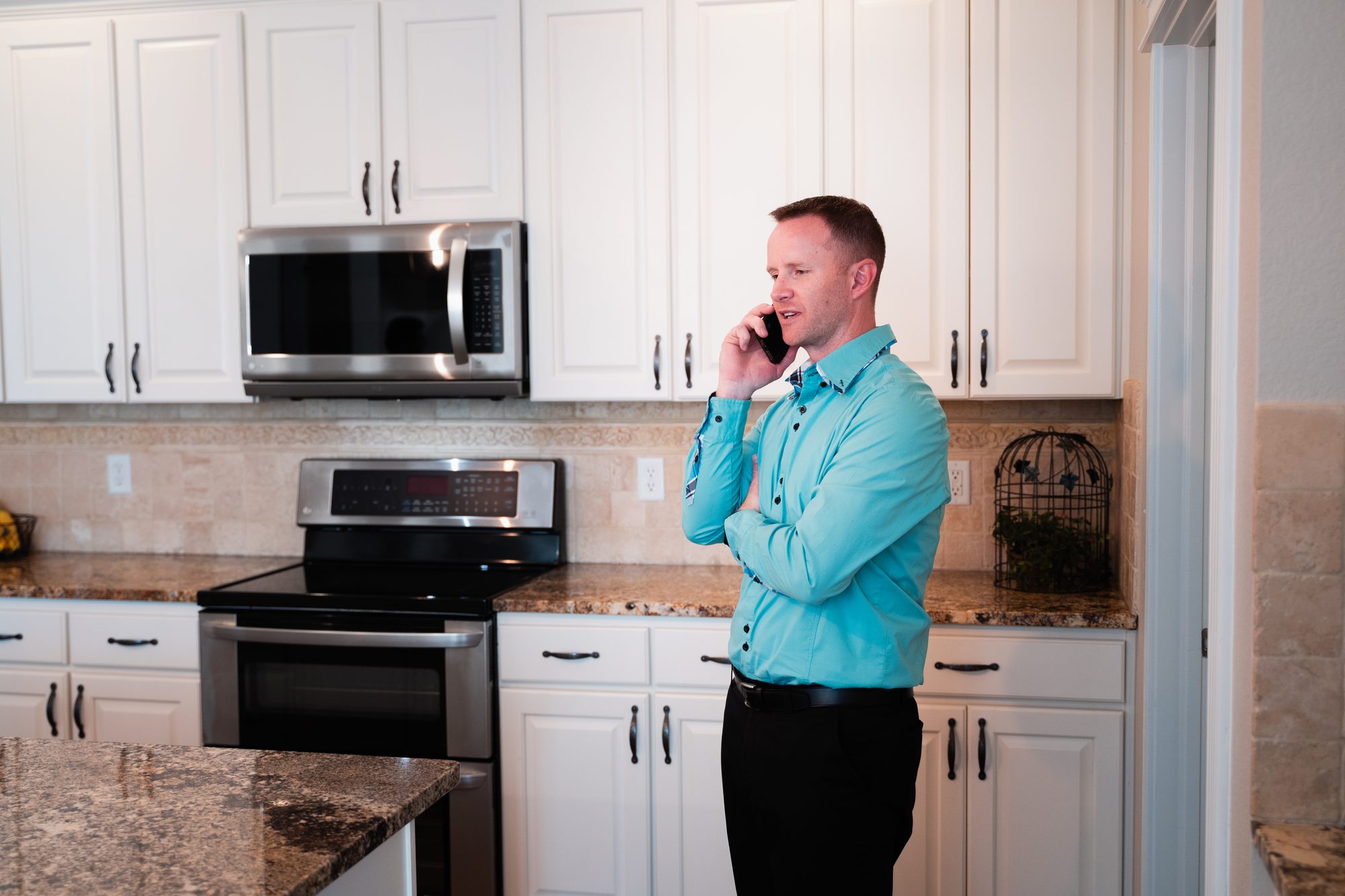 Steve Calley on a phone call in a white kitchen.