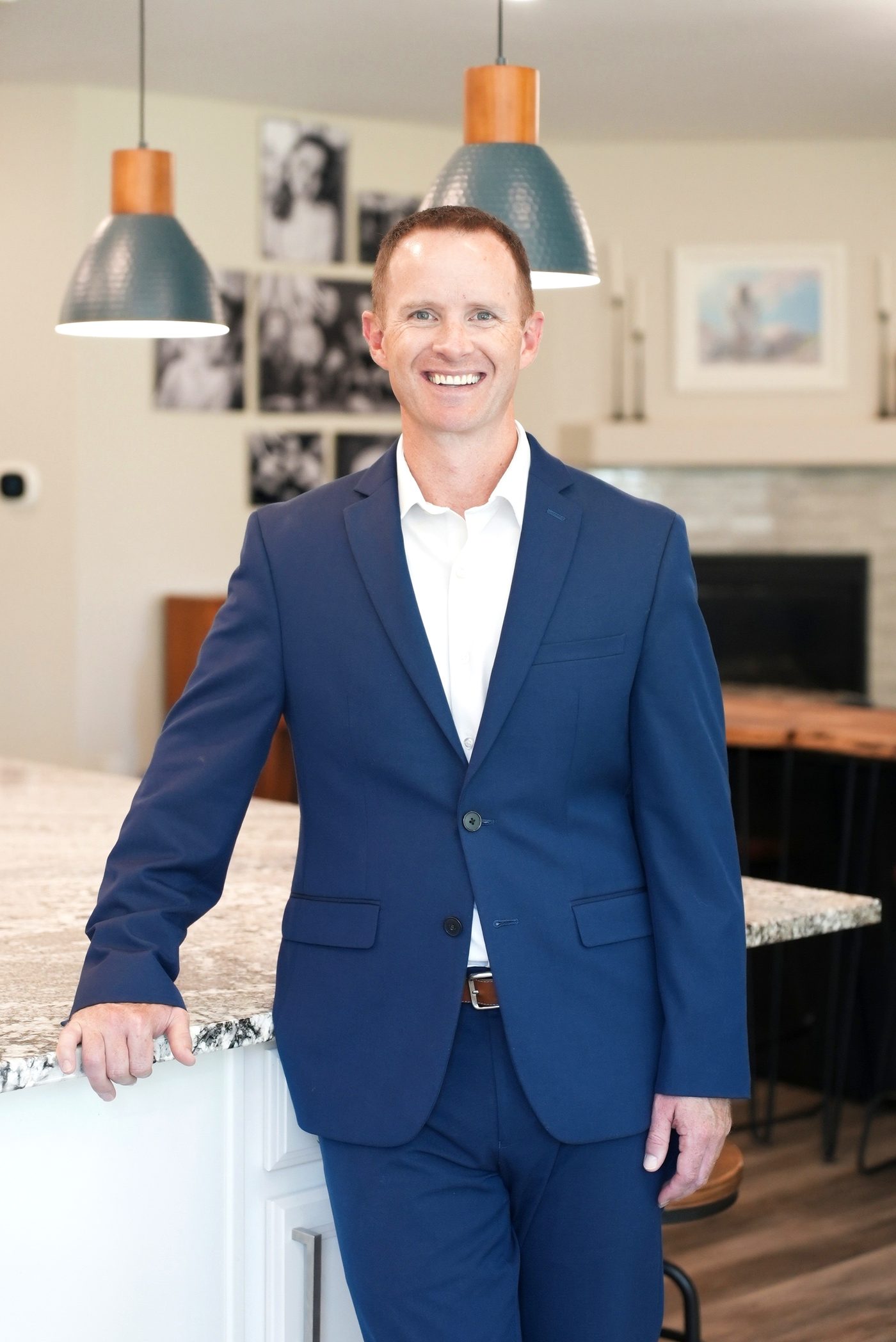 Steve Calley, REALTOR with The Calley Group, smiling in a navy suit beside a kitchen island.