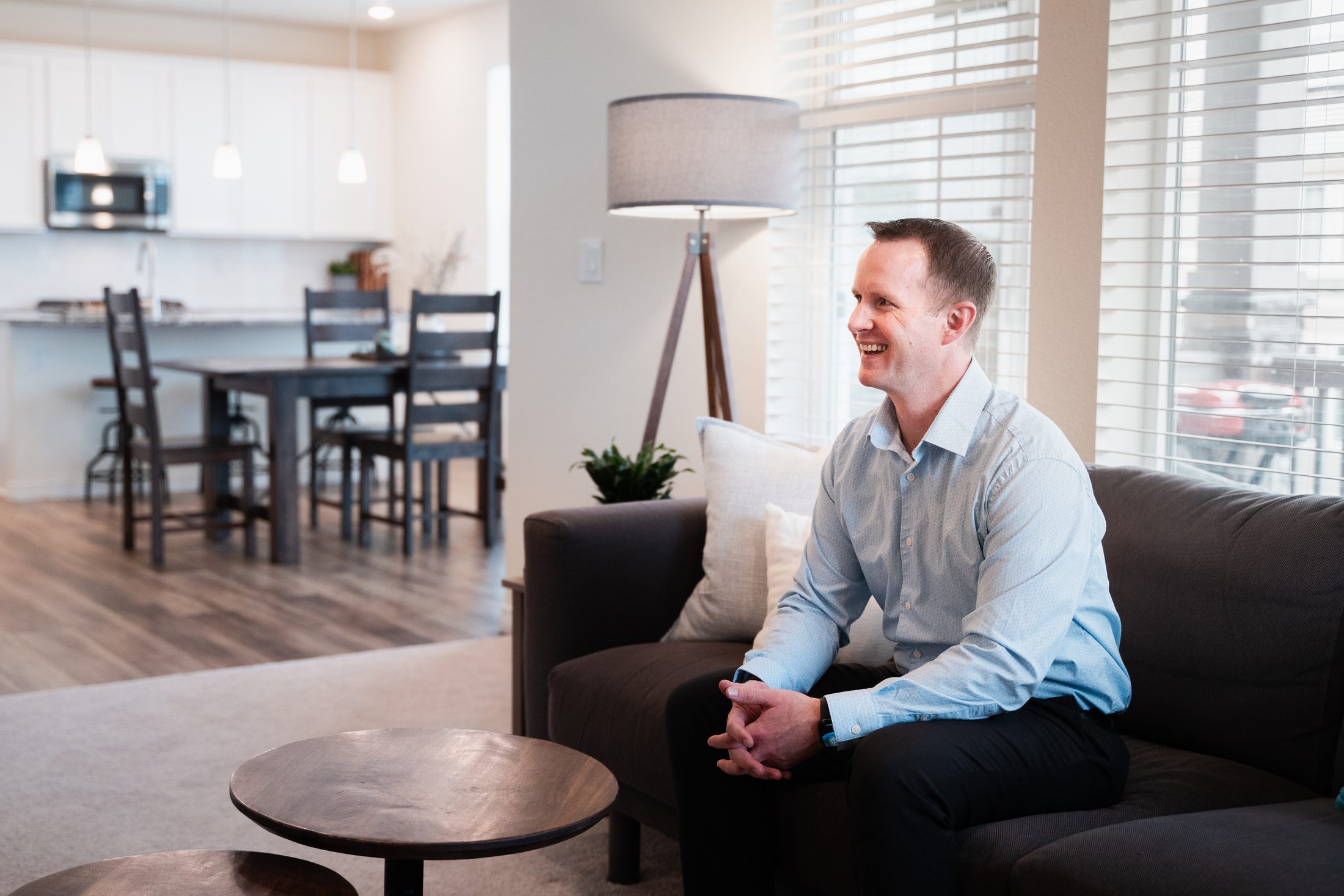 Steve Calley sitting on a sofa in a bright, open living room of a home for sale.