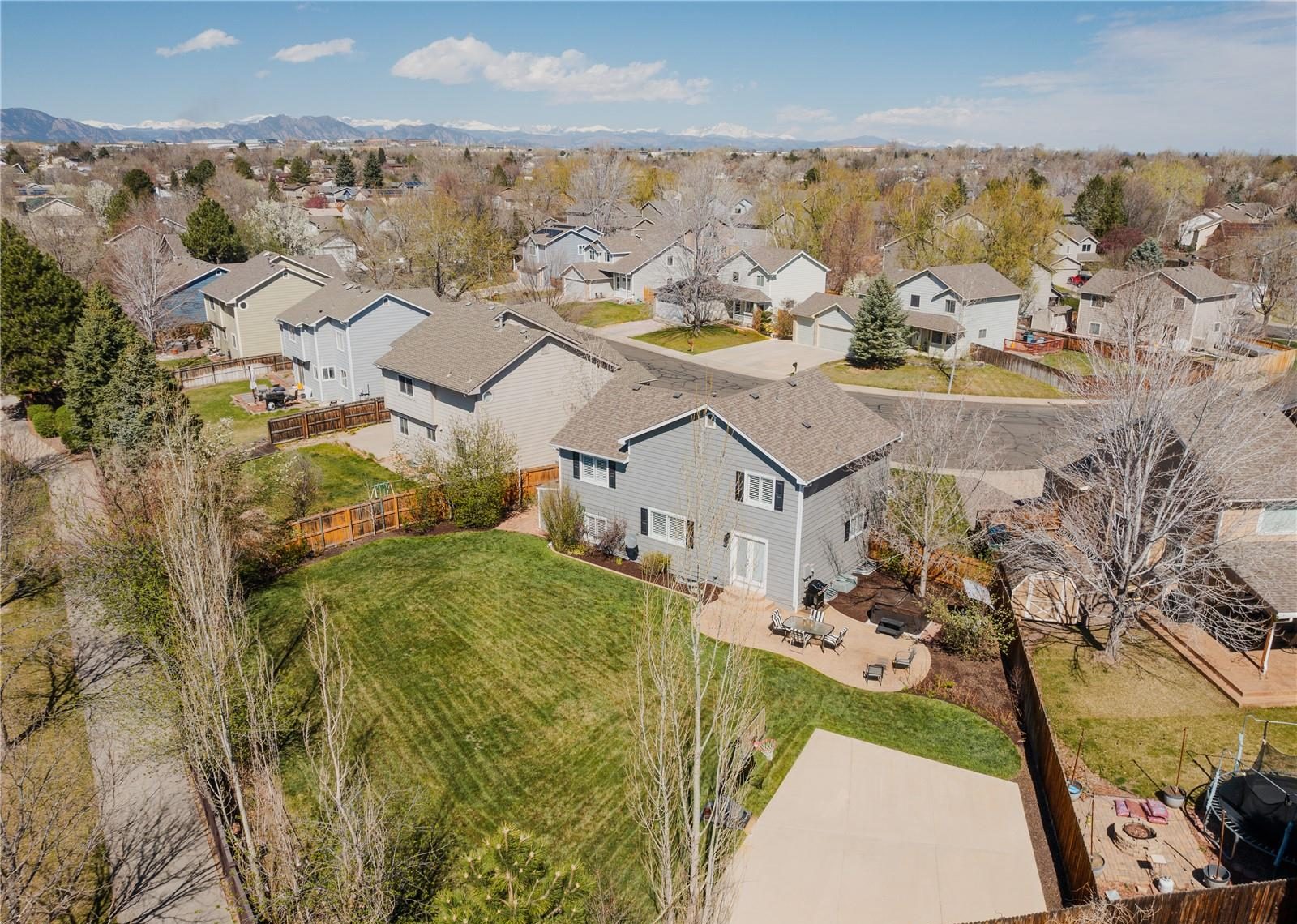 Aerial view over a Westminster neighborhood with the Front Range behind it.
